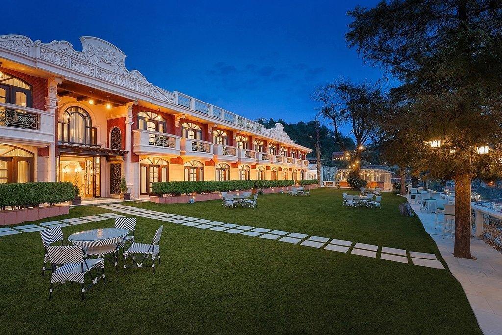 Hotel Ramada Mussoorie lawn and facade in the evening.